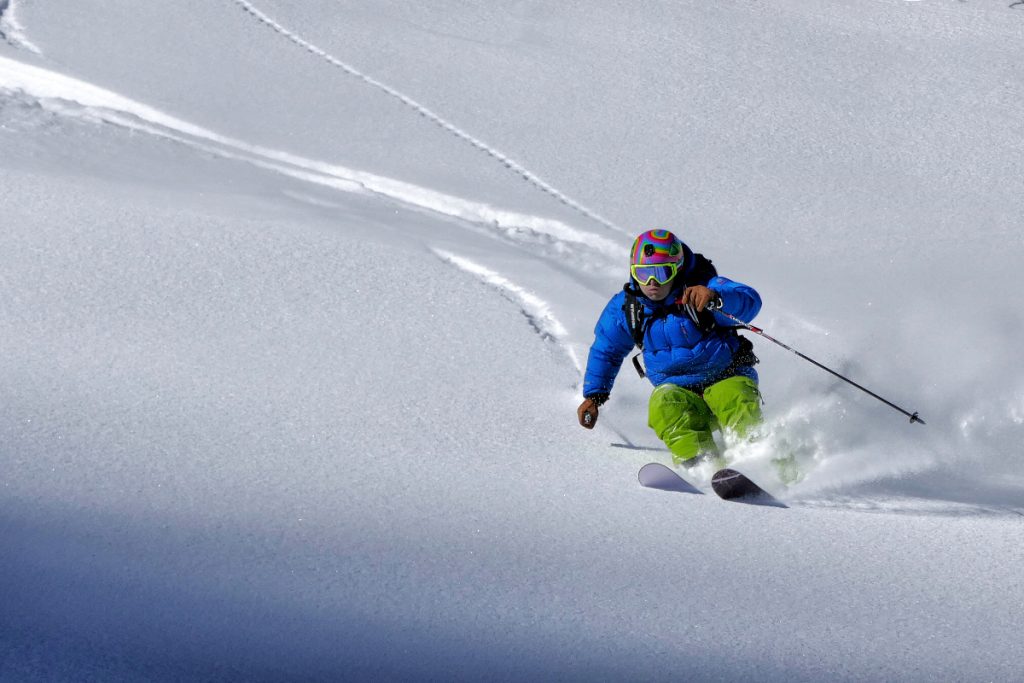 A man skiing downhill, a source of common skiing injuries.