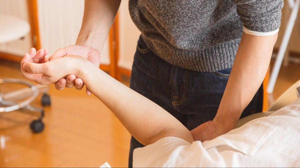 pexels-photo-5473223 crop chiropractor massaging hand of patient