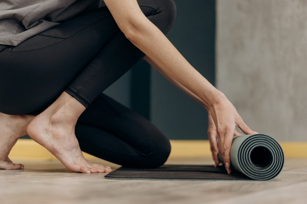 woman unrolling a yoga mat